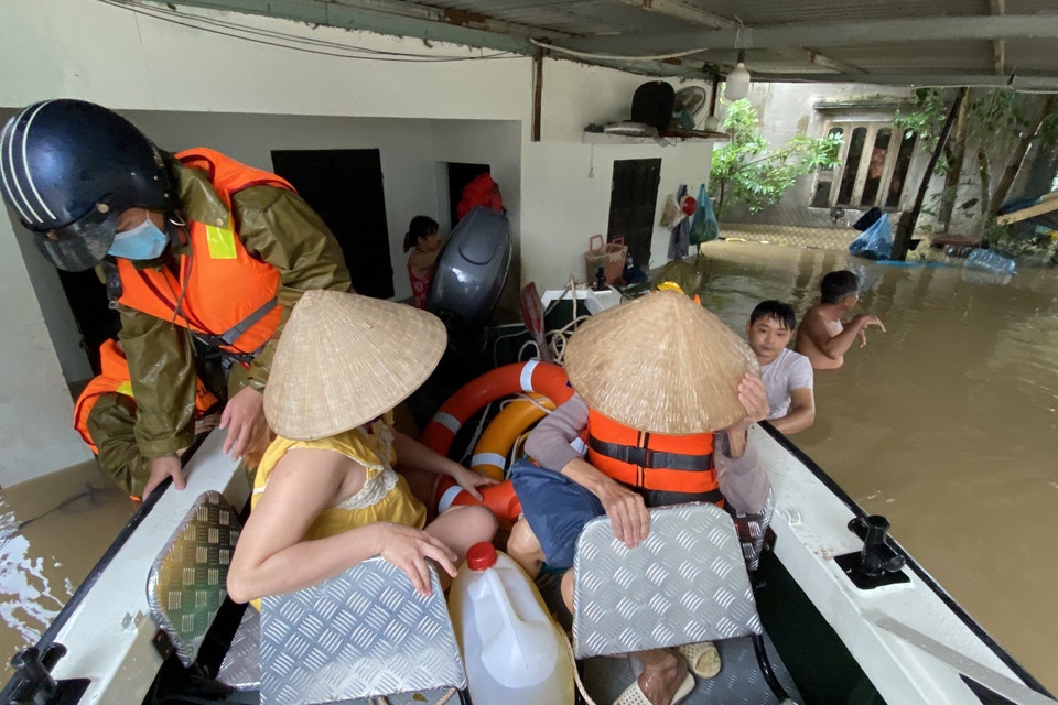 Công an huyện Tuy Phước, tỉnh Bình Định hỗ trợ di dời người dân xã Phước Nghĩa. (Ảnh: Tường Quân/TTXVN)