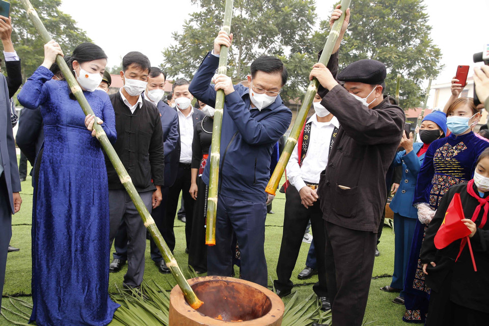 Chủ tịch Quốc hội Vương Đình Huệ và các đại biểu cùng nhân dân giã bánh dày truyền thống. (Ảnh: Doãn Tấn/TTXVN)