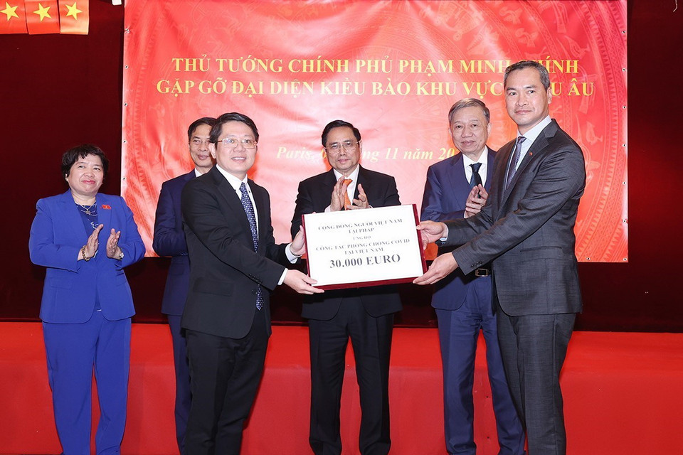 Thủ tướng Phạm Minh Chính chứng kiến trao biểu trưng ủng hộ phòng, chống dịch. (Ảnh: Dương Giang/TTXVN)