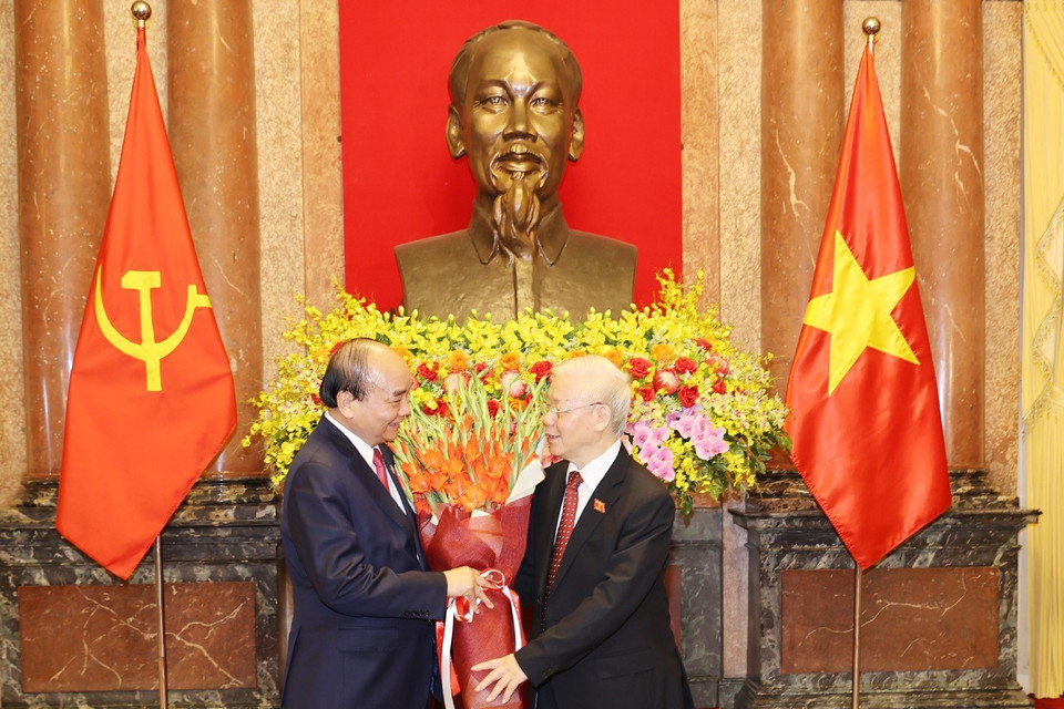 Chủ tịch nước Nguyễn Xuân Phúc tặng hoa Tổng Bí thư Nguyễn Phú Trọng, nguyên Chủ tịch nước. (Ảnh: Trí Dũng/TTXVN)