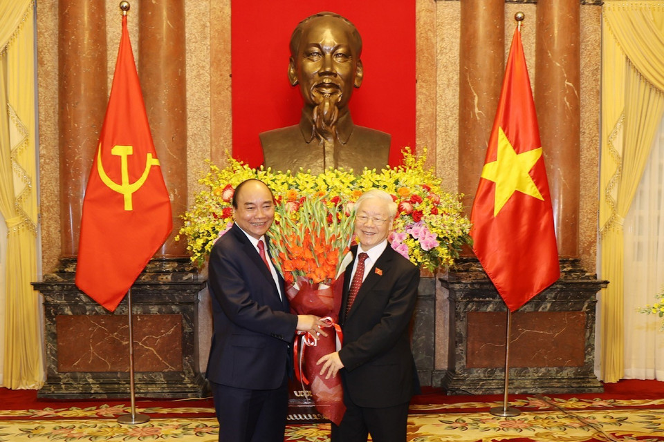 Chủ tịch nước Nguyễn Xuân Phúc tặng hoa Tổng Bí thư Nguyễn Phú Trọng, nguyên Chủ tịch nước. (Ảnh: Trí Dũng/TTXVN)