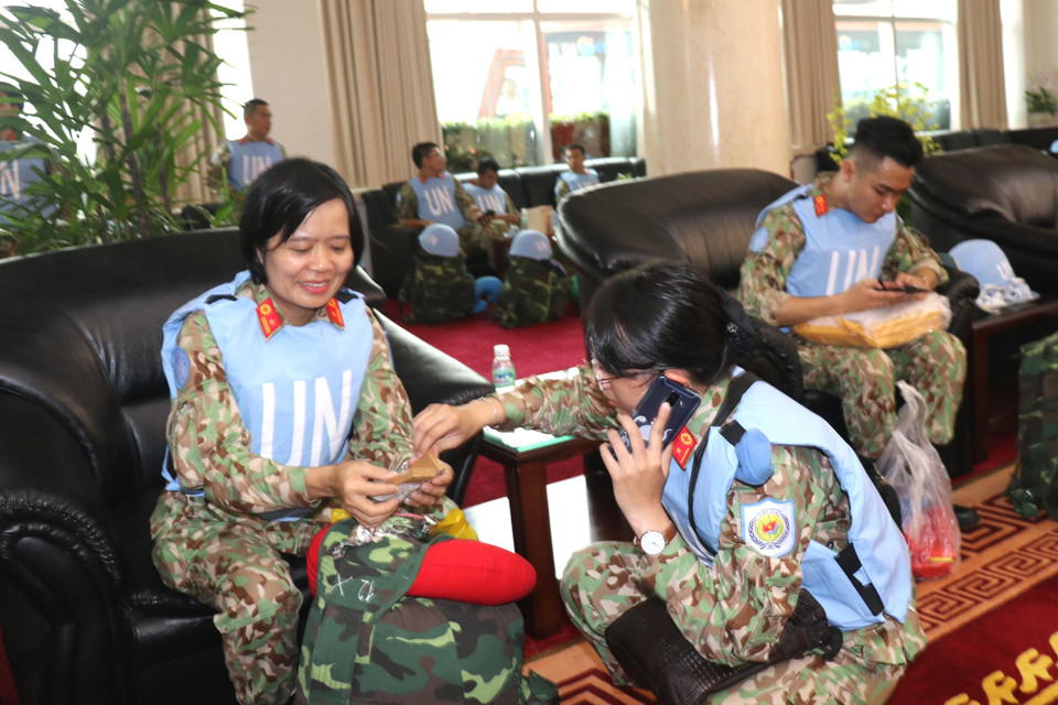 Thiếu tá Bùi Thị Xoa (bên trái), "chị cả" của nhóm 10 nữ cán bộ, nhân viên Bệnh viện Dã chiến cấp 2 số 1, chăm sóc Thiếu úy Huỳnh Cẩm Thơ trước lúc lên máy bay sang Nam Sudan. (Ảnh: Xuân Khu/TTXVN)