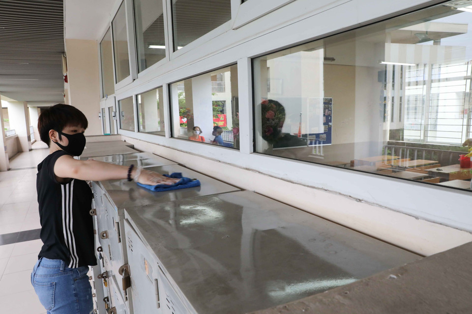 Phụ huynh cùng giáo viên Trường THCS Nghĩa Tân (quận Cầu Giấy) tiến hành vệ sinh, khử khuẩn toàn bộ trường học. (Ảnh: Thanh Tùng/TTXVN)