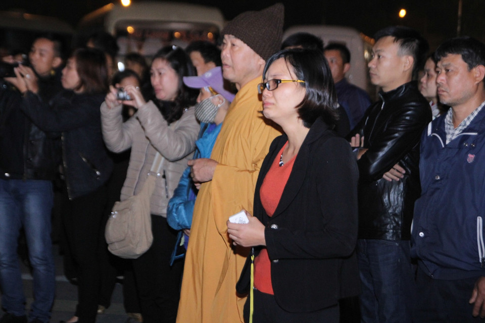 Chị Huyền dường như đã cạn khô nước mắt khi nhìn thấy thi hài chồng mình được đưa đi. (Ảnh Minh Sơn/Vietnam+)