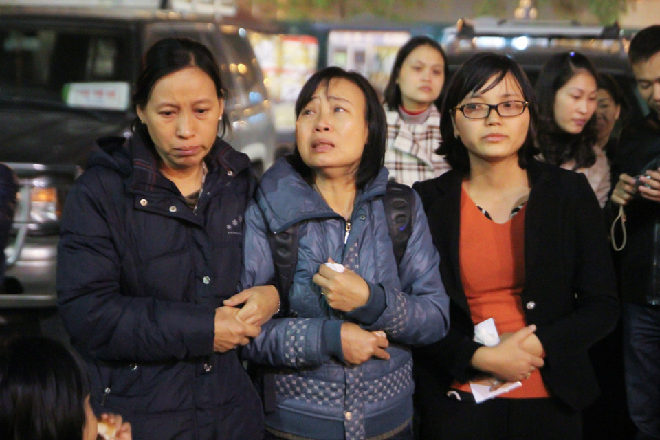 Chị gái anh Đạt khóc nấc, phải để người thân dìu khi chuẩn bị nhận linh cữu. (Ảnh Minh Sơn/Vietnam+)