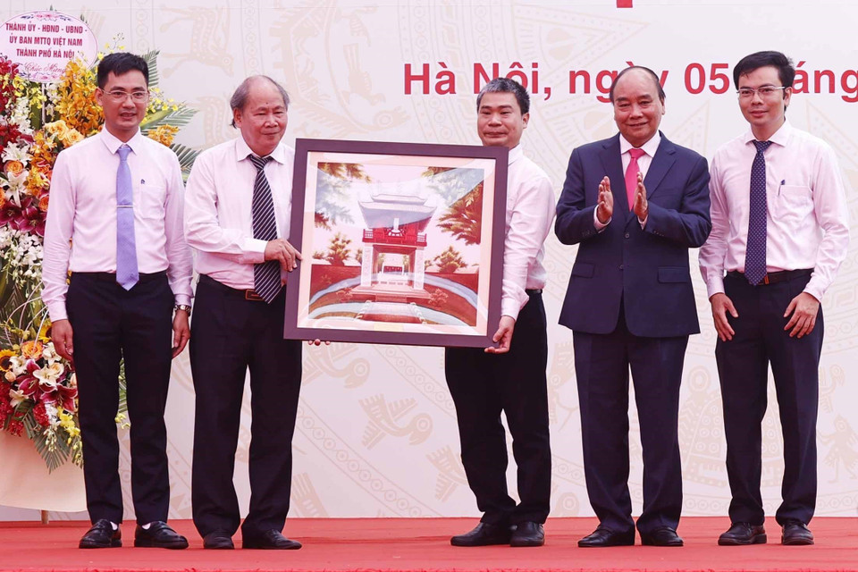 Chủ tịch nước Nguyễn Xuân Phúc tặng quà lưu niệm cho Trường THPT Chuyên Khoa học Tự nhiên. (Ảnh: Thống Nhất/TTXVN)