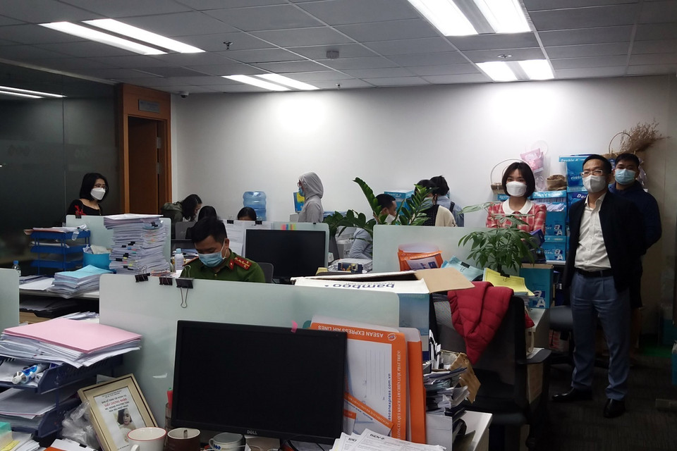 Lực lượng chức năng khám xét và thu giữ tài liệu tại trụ sở FLC. (Ảnh: Phạm Kiên/TTXVN)