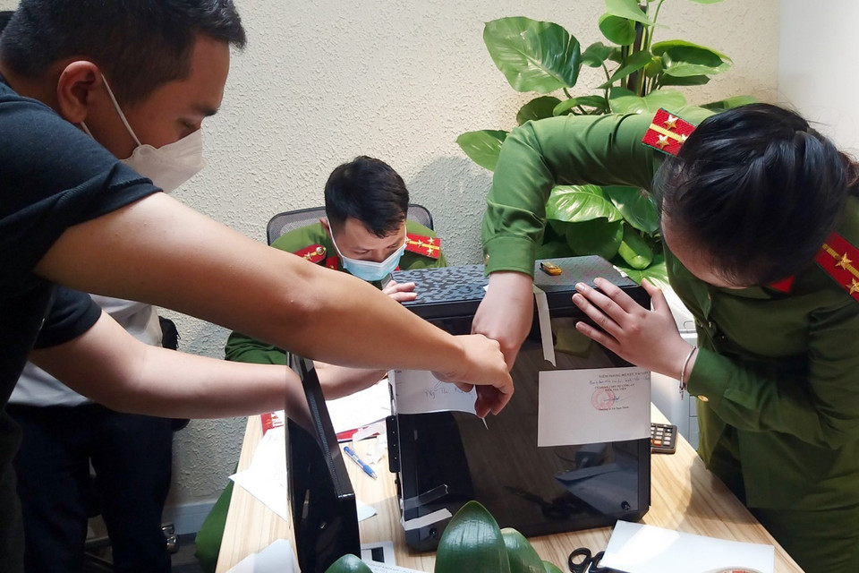 Lực lượng chức năng khám xét và niêm phong, thu giữ tài liệu tại trụ sở FLC. (Ảnh: Phạm Kiên/TTXVN)