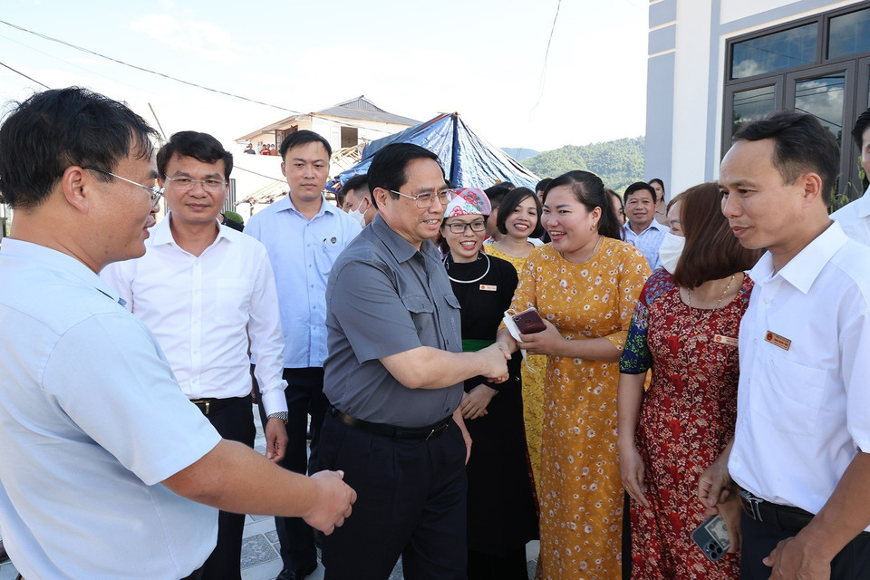 Thủ tướng Phạm Minh Chính thăm hỏi người dân khu tái định cư dự án Cảng hàng không Sa Pa tại xã Cạm Cọn, huyện Bảo Yên. (Ảnh: Dương Giang-TTXVN)