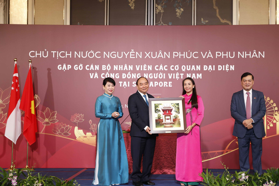 Chủ tịch nước Nguyễn Xuân Phúc tặng quà lưu niệm cho cán bộ, nhân viên Đại sứ quán Việt Nam tại Singapore. (Ảnh: Thống Nhất/TTXVN)