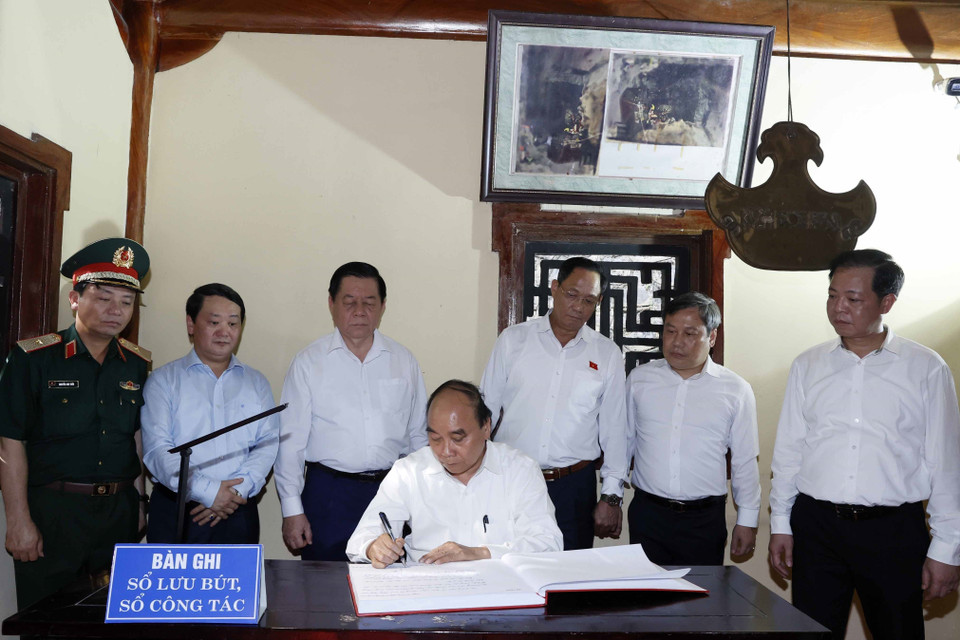 Chủ tịch nước Nguyễn Xuân Phúc ghi lưu bút tại Đền thờ Liệt sỹ Hang 8 thanh niên xung phong. (Ảnh: Thống Nhất/TTXVN)