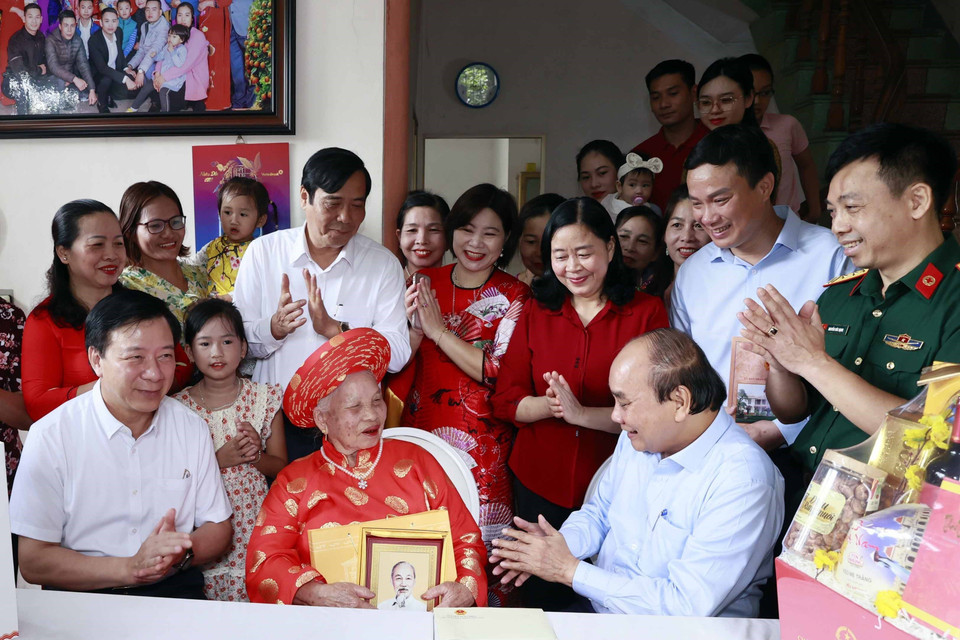 Chủ tịch nước Nguyễn Xuân Phúc thăm và tặng quà cho cụ Phạm Thị Lĩu. (Ảnh: Thống Nhất/TTXVN)