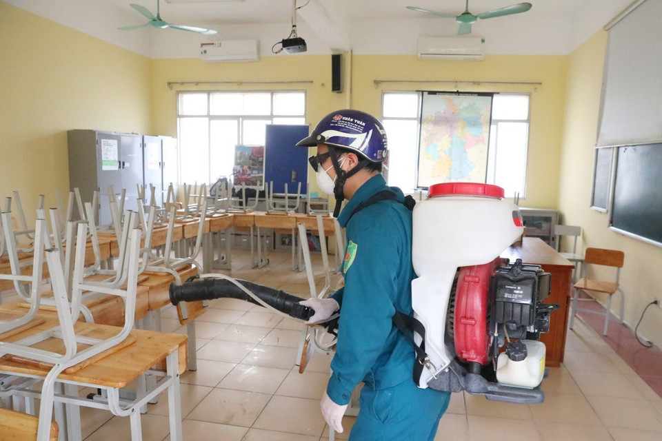  Nhân viên y tế quận Hoàn Kiếm (Hà Nội) phun thuốc khử trùng Chloramin B các phòng học trường THPT Việt Đức. (Ảnh: Thành Đạt/TTXVN)