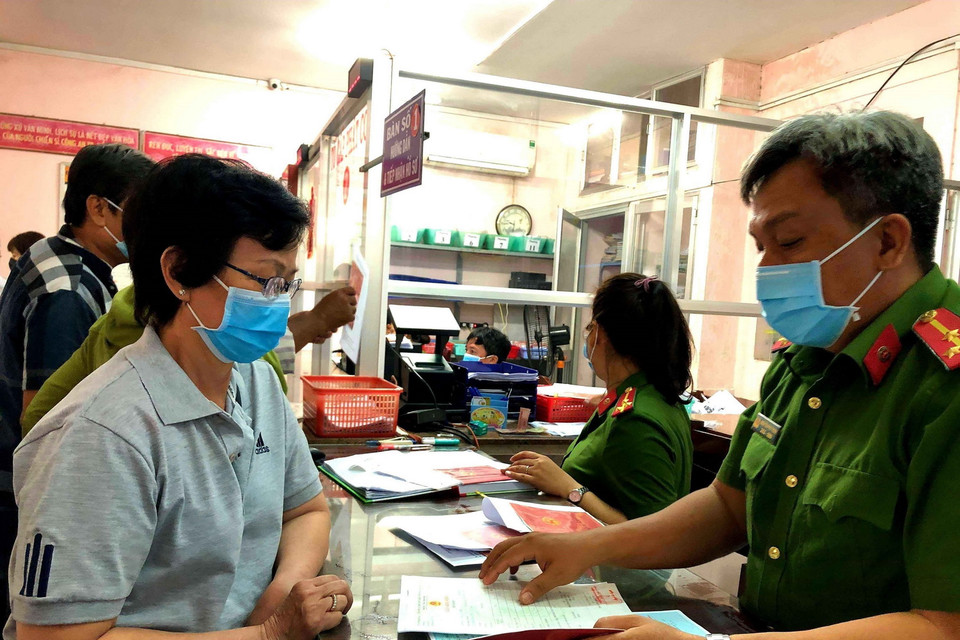 Cán bộ Đội Cảnh sát Quản lý hành chính về trật tự xã hội, Công an quận Bình Thạnh (TP Hồ Chí Minh) và người dân chủ động đeo khẩu trang khi làm việc. (Ảnh: Thành Chung/TTXVN)