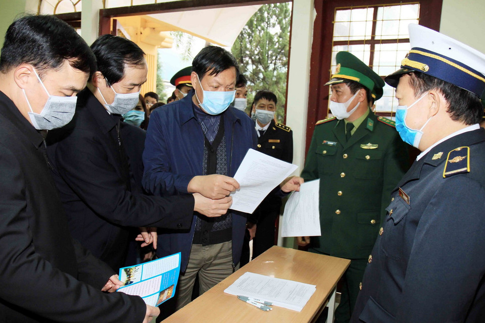 Thứ trưởng Bộ Y tế Đỗ Xuân Tuyên kiểm tra việc khai báo của khách nhập cảnh qua Cửa khẩu Quốc tế Hữu Nghị, tỉnh Lạng Sơn. (Ảnh: Thái Thuần/TTXVN)