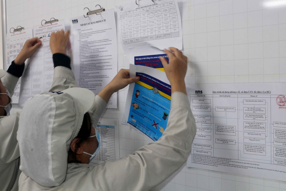 Dán thông tin và cách phòng chống dịch bệnh nCoV tại bản tin của doanh nghiệp cho công nhân theo dõi trong khu công nghiệp ở Hà Nam. (Ảnh: Đại Nghĩa/TTXVN)