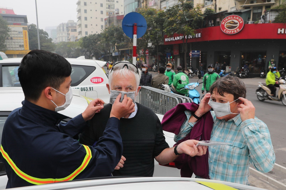 Phát miễn phí khẩu trang y tế cho du khách nước ngoài phòng chống dịch nCoV ở Hà Nội. (Ảnh: Thành Đạt/TTXVN)