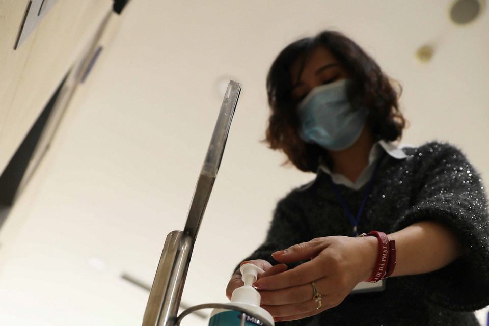 Cán bộ, nhân viên Thông tấn xã Việt Nam rửa tay bằng nước kháng khuẩn. (Ảnh: Lâm Khánh/TTXVN)