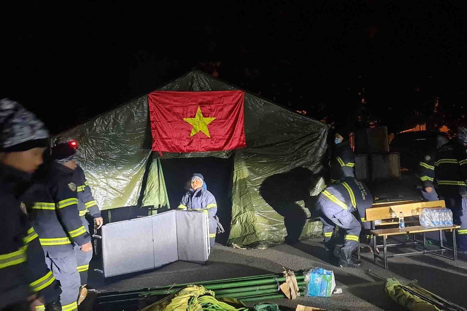 Đoàn công tác dựng lều chuẩn bị cho công tác cứu hộ. (Ảnh: TTXVN phát)