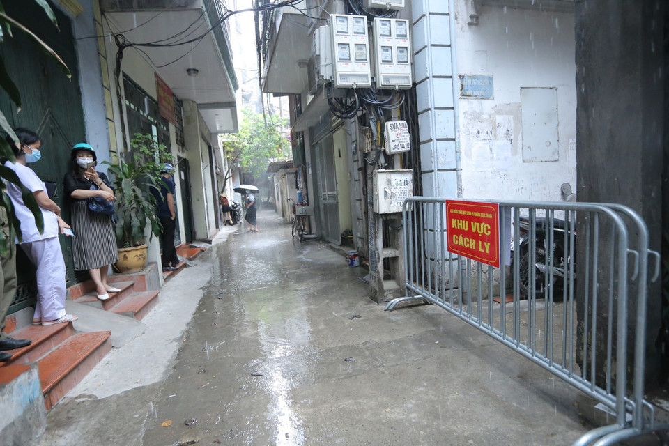 Lực lượng chức năng phong tỏa 3 ngõ, gồm 26 hộ, khu vực nơi nam bác sỹ sống. (Ảnh: Hoàng Hiếu/TTXVN)