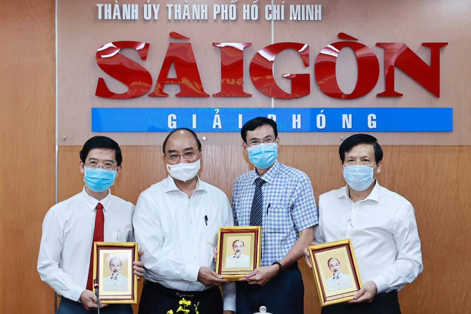 Chủ tịch nước Nguyễn Xuân Phúc tặng chân dung Chủ tịch Hồ Chí Minh cho Ban biên tập Báo Sài Gòn Giải phóng. (Ảnh: Thống Nhất/TTXVN)