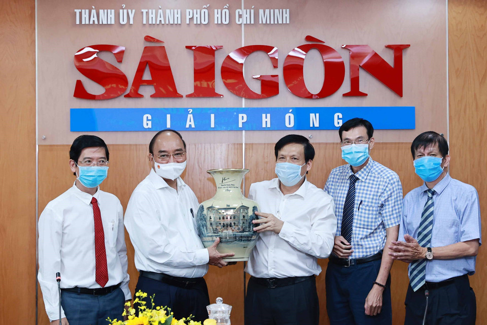 Chủ tịch nước Nguyễn Xuân Phúc tặng quà lưu niệm cho Báo Sài Gòn Giải phóng. (Ảnh: Thống Nhất/TTXVN)