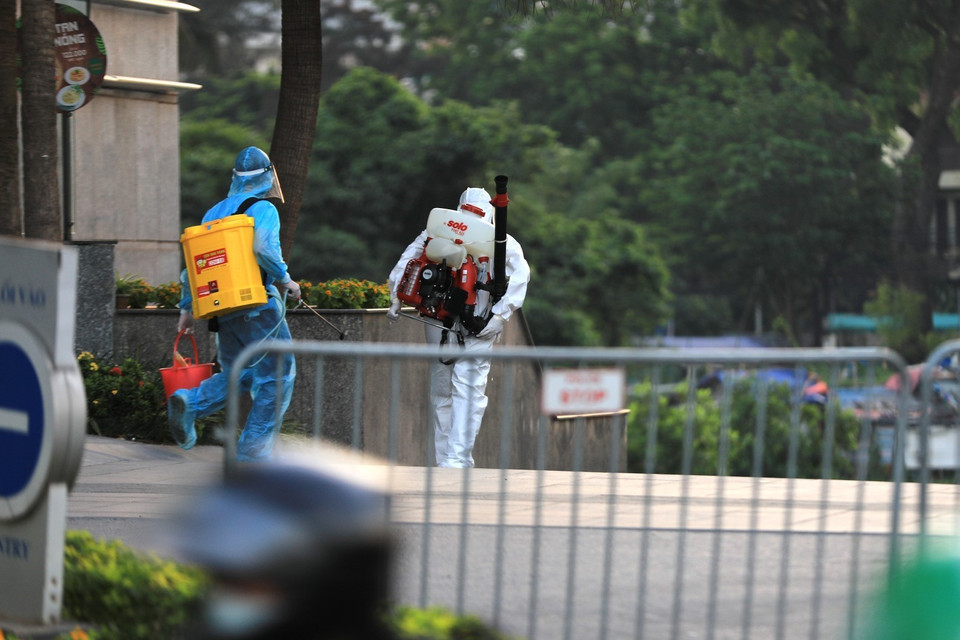 Lực lượng y tế quận Tây Hồ tiến hành phun khử khuẩn tòa nhà Fraser Suites. (Ảnh: Thành Đạt/TTXVN)