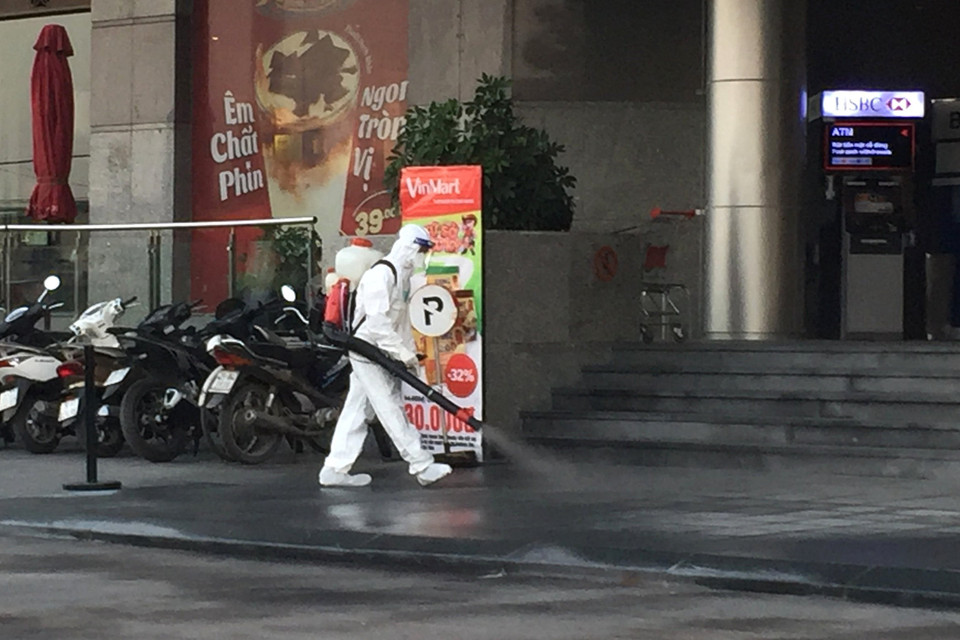 Lực lượng y tế quận Tây Hồ tiến hành phun khử khuẩn tòa nhà Fraser Suites. (Ảnh: Thành Đạt/TTXVN)