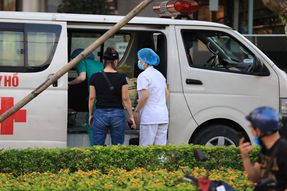 Chiều 29/5, lực lượng chức năng Trung tâm Y tế quận Tây Hồ có mặt tại tòa nhà Fraser Suites để tiến hành các thủ tục đưa bệnh nhân đi cách ly y tế tập trung. (Ảnh: Thành Đạt/TTXVN)