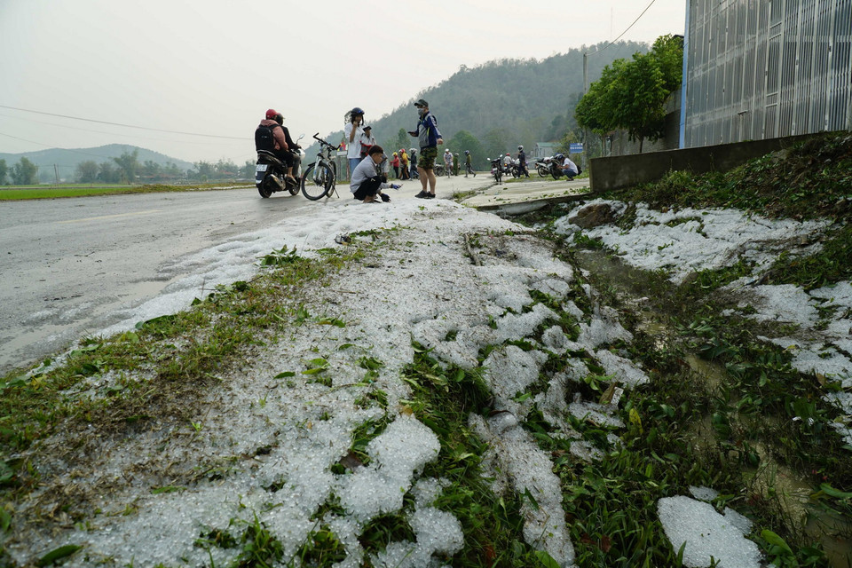 Mưa đá phủ trắng hai bên đường. (Ảnh: Xuân Tư/TTXVN)