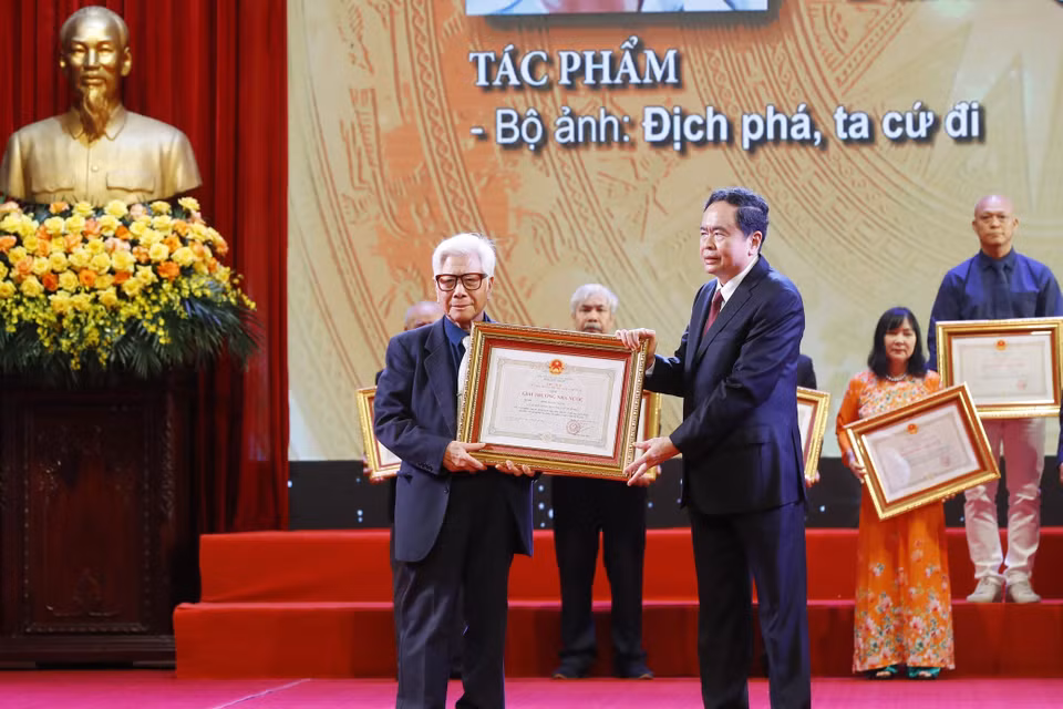 Phó Chủ tịch Thường trực Quốc hội Trần Thanh Mẫn trao Giải thưởng Nhà nước tặng tác giả Phạm Văn Thính, nguyên phóng viên Thông tấn xã Việt Nam với bộ ảnh "Địch phá, ta cứ đi." (Ảnh: Lâm Khánh/TTXVN)