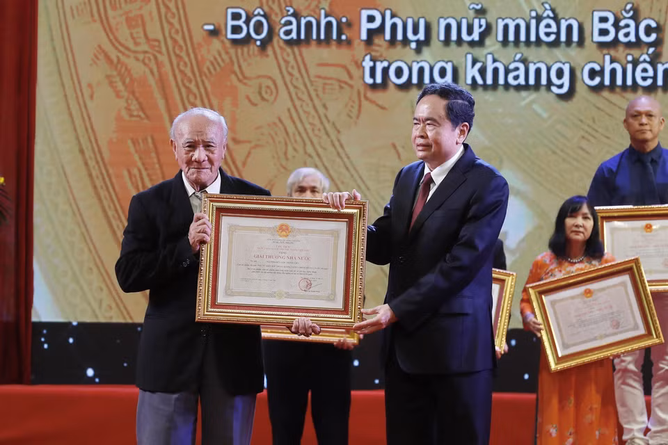 Phó Chủ tịch Thường trực Quốc hội Trần Thanh Mẫn trao Giải thưởng Nhà nước tặng tác giả Nguyễn Hữu Lộc (Hữu Lộc), nguyên phóng viên Thông tấn xã Việt Nam với bộ ảnh "Phụ nữ miền Bắc trong kháng chiến chống Mỹ cứu nước." (Ảnh: Lâm Khánh/TTXVN)