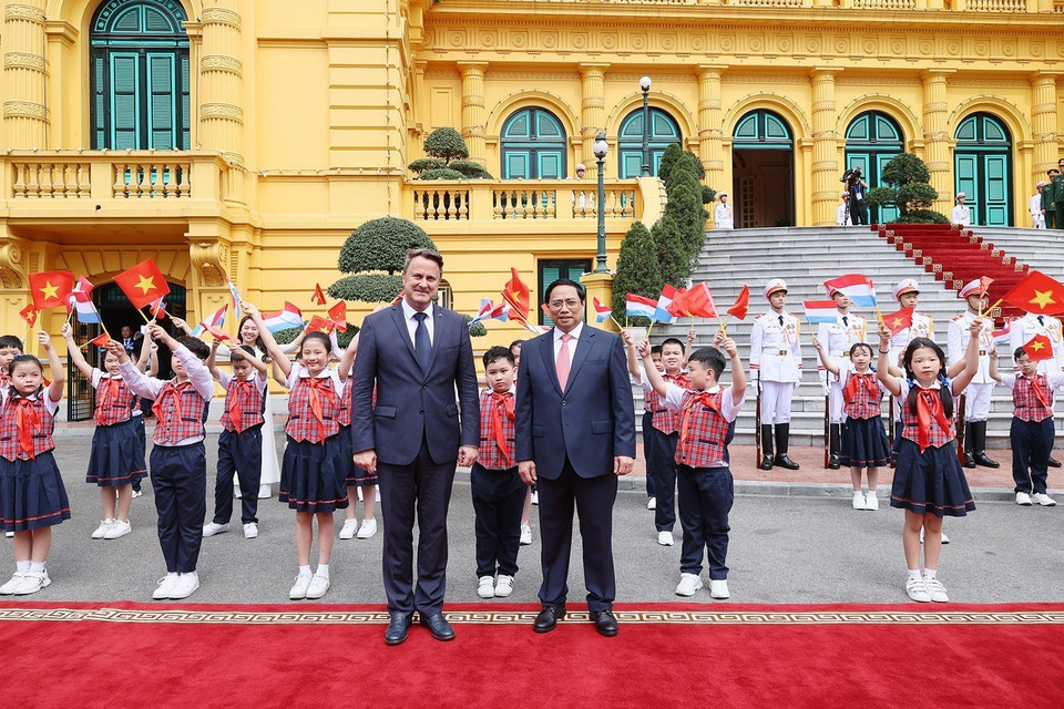 Thủ tướng Phạm Minh Chính và Thủ tướng Đại Công quốc Luxembourg Xavier Bettel với thiếu nhi Thủ đô tại lễ đón. (Ảnh: Dương Giang/TTXVN)