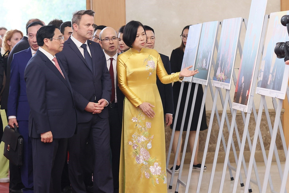 Tổng Giám đốc TTXVN Vũ Việt Trang giới thiệu với Thủ tướng Phạm Minh Chính và Thủ tướng Đại Công quốc Luxembourg Xavier Bettel những hình ảnh về hợp tác giữa Việt Nam-Luxembourg. (Ảnh: Dương Giang/TTXVN)
