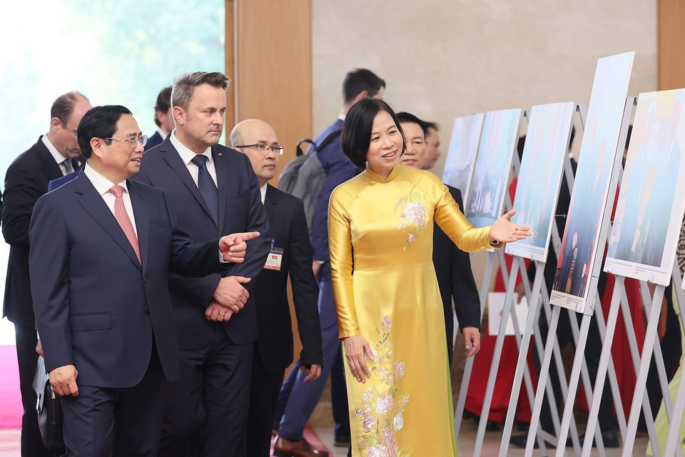 Tổng Giám đốc TTXVN Vũ Việt Trang giới thiệu với Thủ tướng Phạm Minh Chính và Thủ tướng Đại Công quốc Luxembourg Xavier Bettel những hình ảnh về hợp tác giữa Việt Nam-Luxembourg. (Ảnh: Dương Giang/TTXVN)