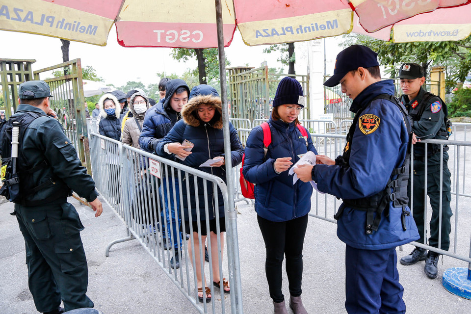 Khi vào đến cổng trụ sở VFF, người đến nhận vé phải xuất trình tờ in mã số đặt vé, bản photo chứng minh thư hoặc giấy ủy quyền có chữ kí của người mua thành công vé. (Ảnh: Minh Sơn/Vietnam+) 