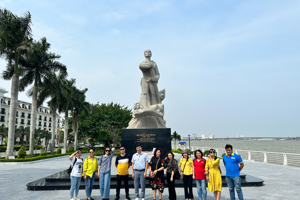 Chụp ảnh lưu niệm tại Tượng đài Mẹ Suốt ở Quảng Bình. (Ảnh: Minh Sơn/Vietnam+)