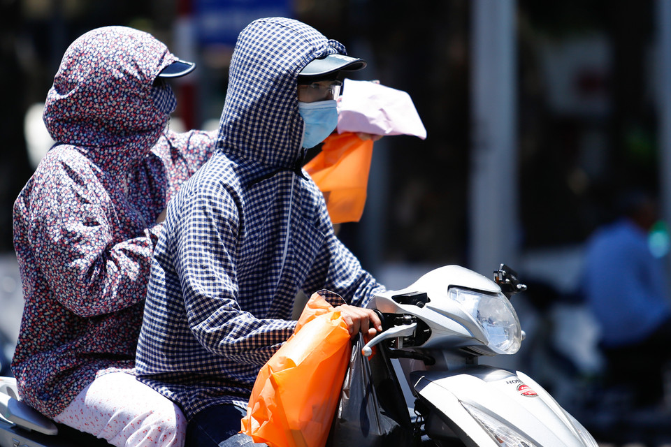 Ra ngoài đường những ngày này, bạn sẽ gặp rất nhiều người đi đường trùm kín như “ninja”. (Ảnh: Minh Chiến/Vietnam+)