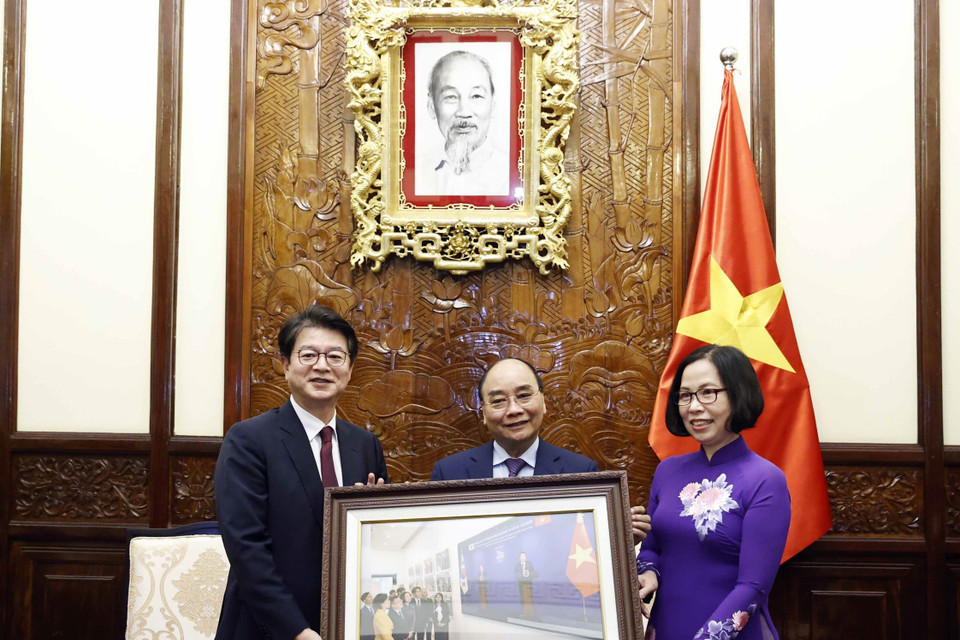 Tổng Giám đốc TTXVN Vũ Việt Trang tặng Chủ tịch nước Nguyễn Xuân Phúc bức ảnh các đại biểu hai nước khai trương và tham quan Triển lãm "30 năm Hợp tác Việt Nam-Hàn Quốc" sáng 14/12 tại Hà Nội. (Ảnh: Thống Nhất/TTXVN)