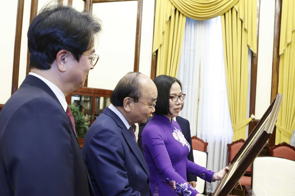 Tổng Giám đốc TTXVN Vũ Việt Trang tặng Chủ tịch nước Nguyễn Xuân Phúc bức ảnh các đại biểu hai nước khai trương và tham quan Triển lãm "30 năm Hợp tác Việt Nam-Hàn Quốc" sáng 14/12 tại Hà Nội. (Ảnh: Thống Nhất/TTXVN)