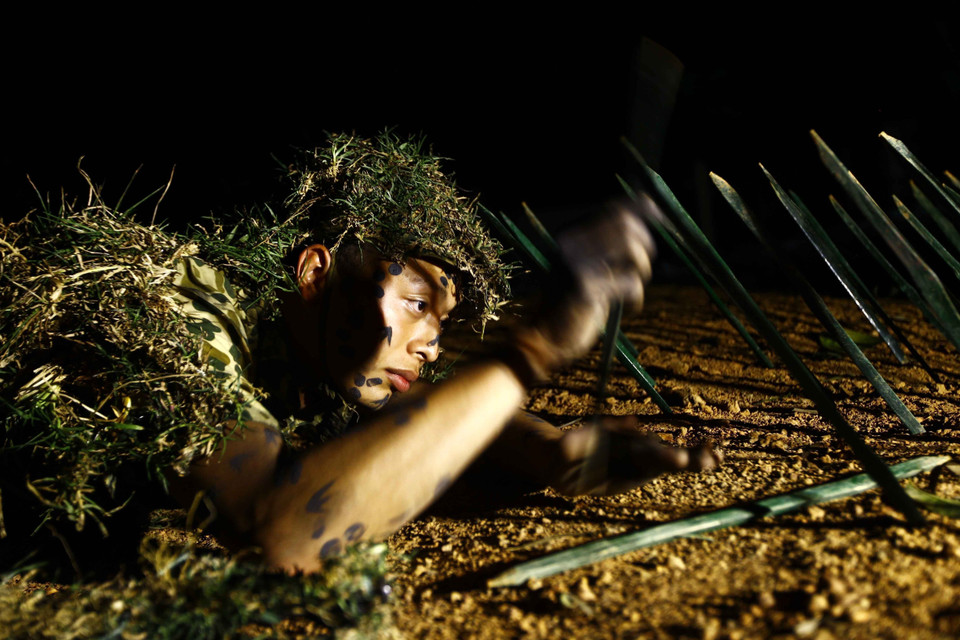 Chiến sỹ Lữ đoàn Đặc công 113 luyện tập vô hiệu hóa từng chiếc chông trong đêm để đồng đội phía sau tiến lên đột nhập căn cứ địch. (Ảnh: An Đăng/TTXVN)