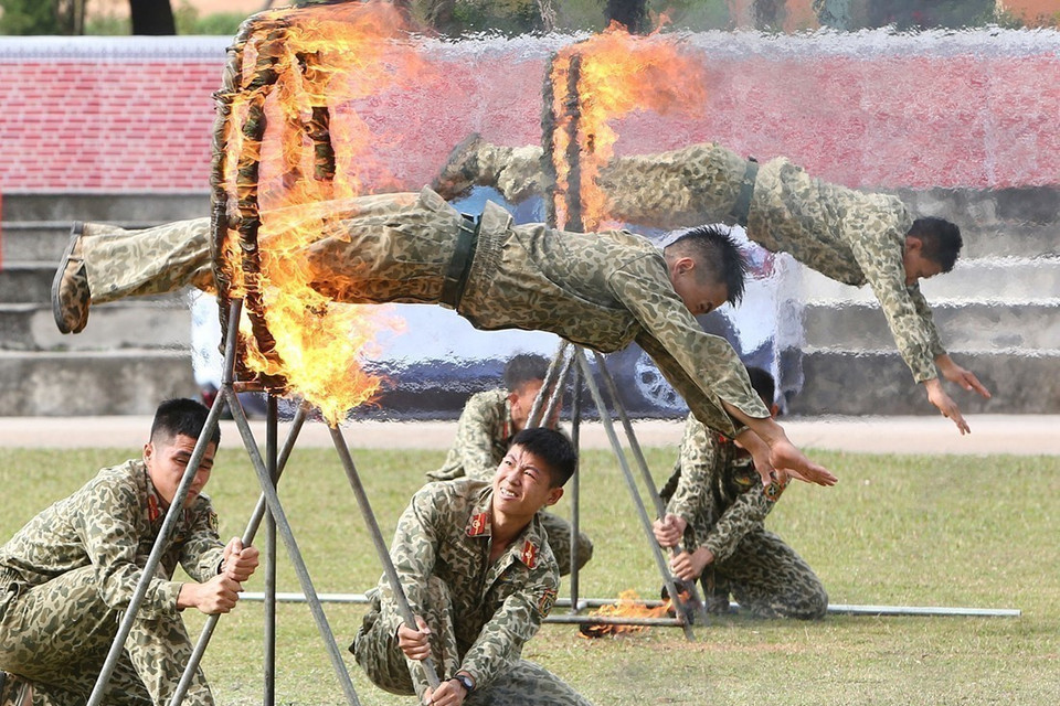 Bộ đội Đặc công trình diễn các kỹ thuật phi thân qua vòng lửa.(Ảnh: Trọng Đức/TTXVN)