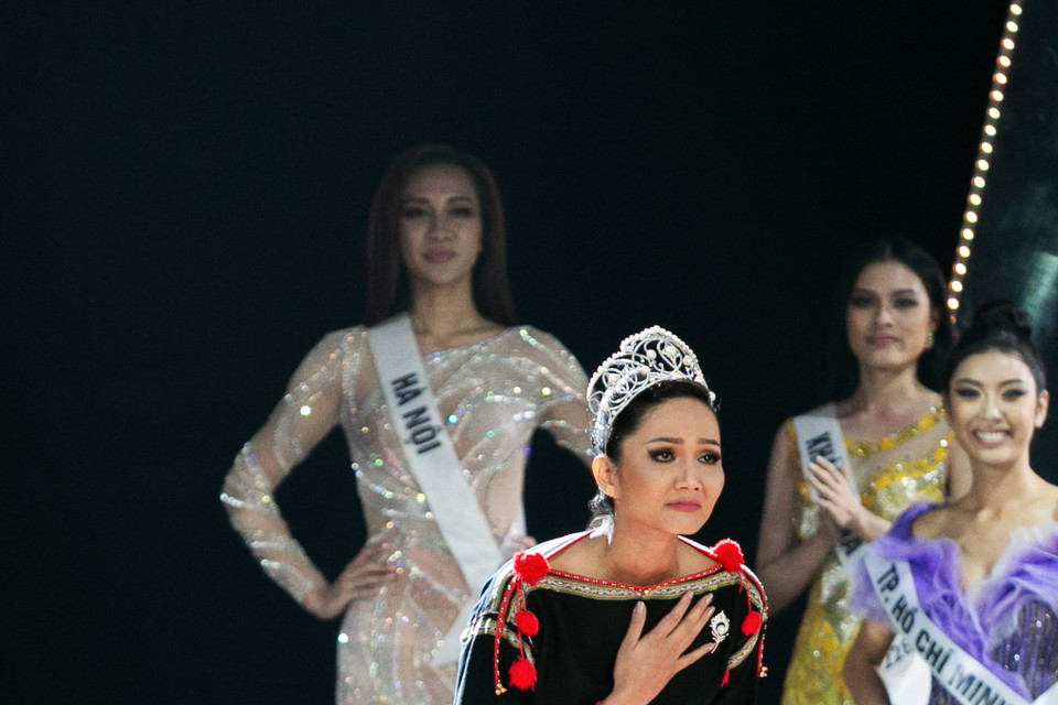 Hoa hậu H’Hen Niê xuất hiện với đôi chân trần và trang phục Êđê, đội vương miện trong màn Final Walk trước khi trao lại danh hiệu cho người kế vị tiếp theo. (Ảnh: Sang Đào/Vietnam+)
