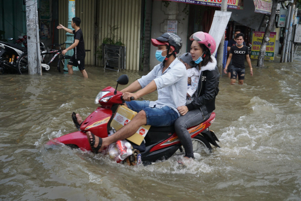 Người dân di chuyển khó khăn trong mùa triều cường. (Ảnh: Trần Xuân Tình/TTXVN)