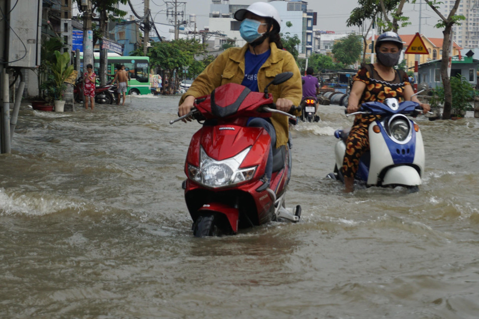 Người dân di chuyển khó khăn trong mùa triều cường. (Ảnh: Trần Xuân Tình/TTXVN)