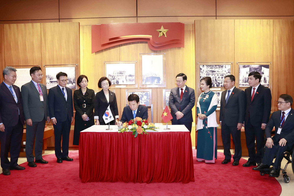 Chủ tịch Quốc hội Hàn Quốc Kim Jin-pyo ký Sổ vàng lưu niệm tại Phòng truyền thống của Quốc hội. (Ảnh: Doãn Tấn/TTXVN)