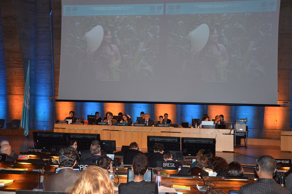 Màn hình lớn tại Hội trường UNESCO chiếu hình ảnh cô thôn nữ hát Ví, Giặm trên nương ngô trong quá trình hội nghị xem xét hồ sơ ứng cử của Việt Nam. (Ảnh: Bích Hà)