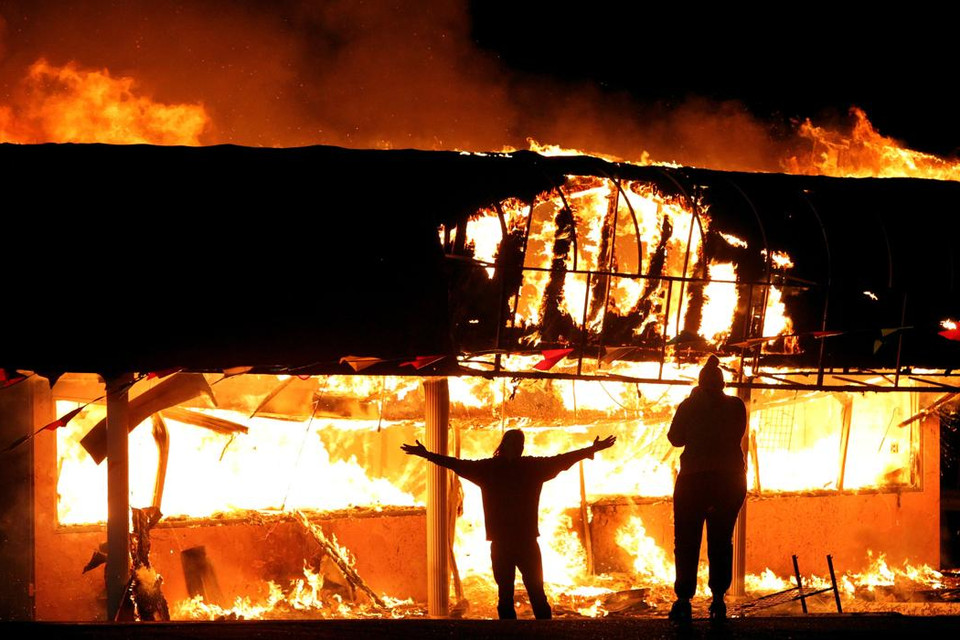 Những người biểu tình chụp ảnh lẫn nhau trước một cửa hàng thời trang Juanita's Fashion R Boutique trên đại lộ West Florissant ở St. Louis, Missouri, Mỹ sớm ngày 25/11. (Nguồn: AP)