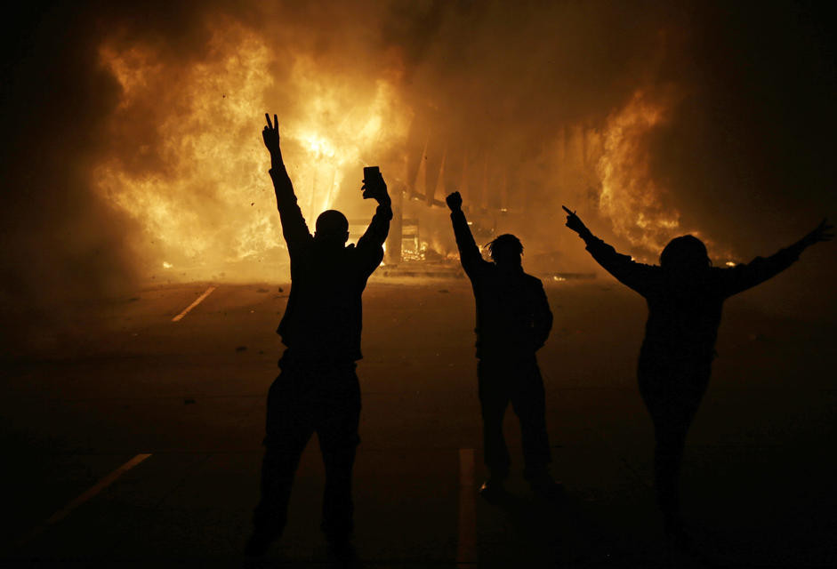 Người dân đứng nhìn các cửa hàng bốc cháy vào thứ 3 ngày 25/11 ở Ferguson, Missouri, Mỹ. (Ngày: AP)