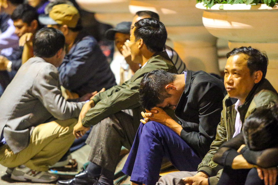 Tại sân Thiên Trường, nhiều người ngồi gục mặt xuống. Theo quan niệm, nếu mua được ấn đền Trần sau giờ khai ấn sẽ đem lại nhiều may mắn, tài lộc và công danh. (Ảnh: PV/Vietnam+)